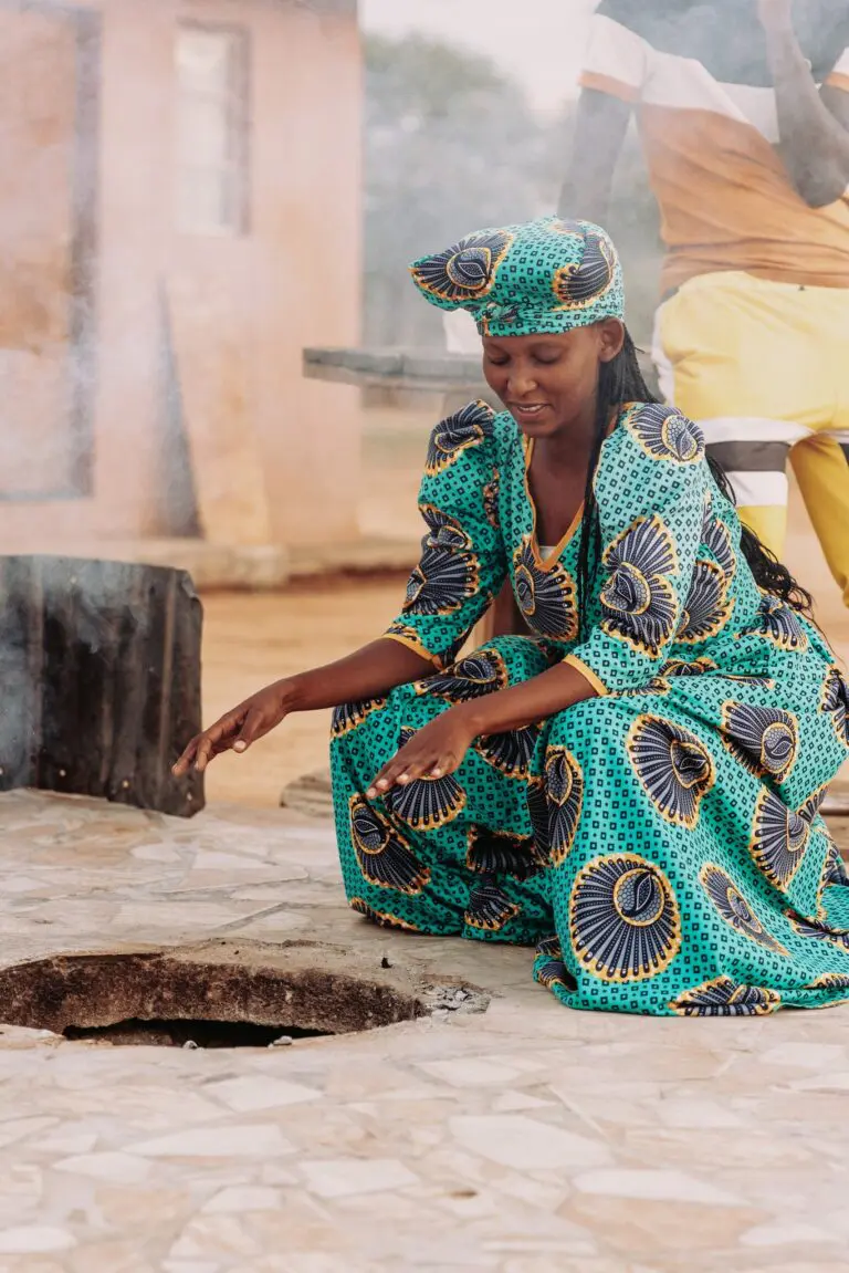 woman in traditional dress cooking outdoors in Namibia