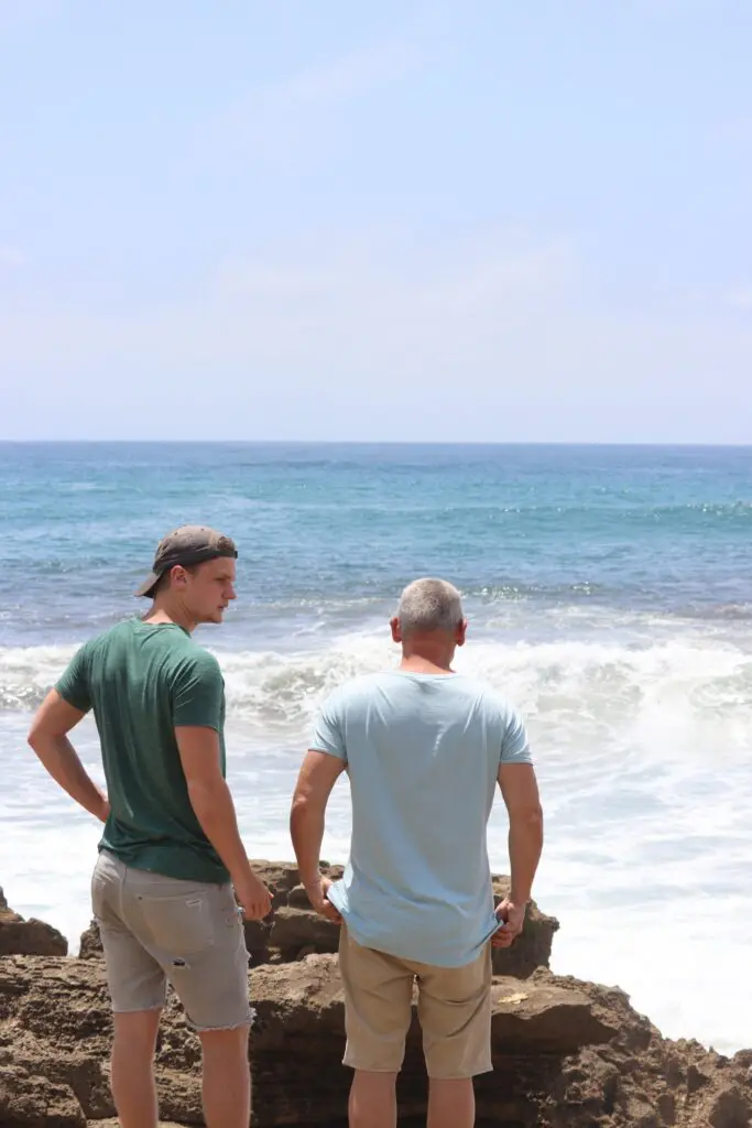 two men on rocky beach looking at ocean in St Lucia