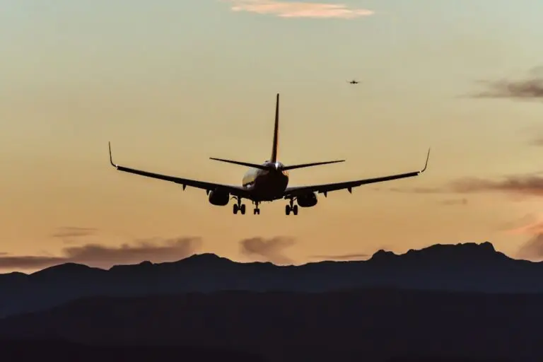 airplane landing at sunset over mountains