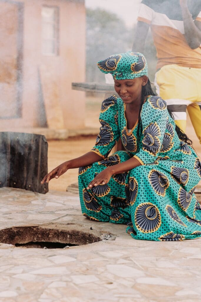 woman in traditional dress cooking outdoors in Namibia