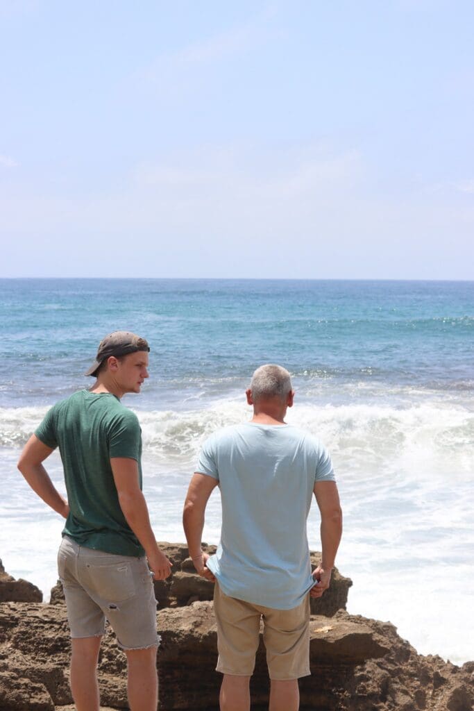 two men on rocky beach looking at ocean in St Lucia