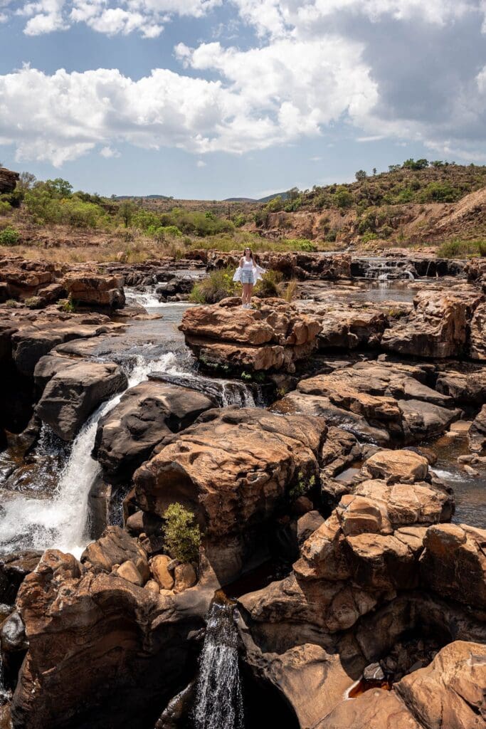 woman standing on rocks in Bourke's Luck Potholes, South Africa